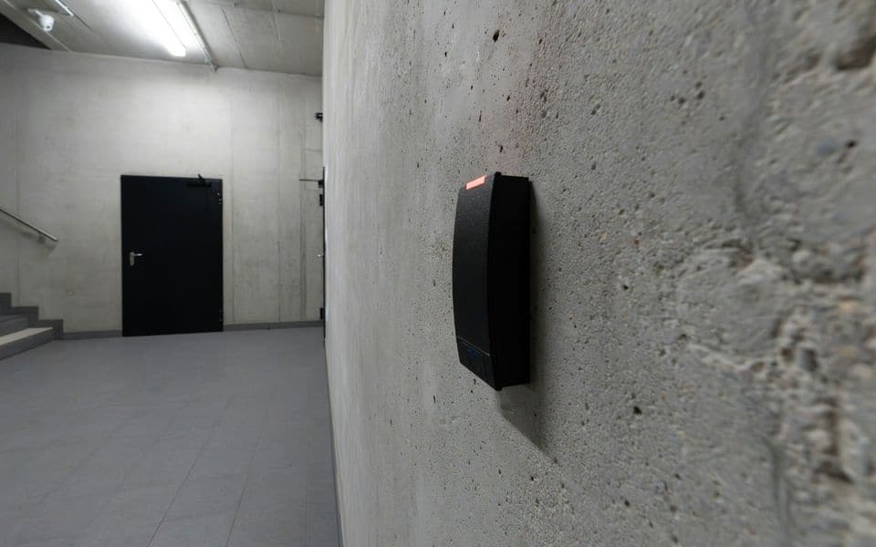 Un lector de tarjetas inteligentes sin contacto instalado junto a una puerta con control de acceso