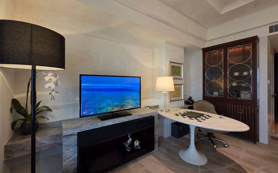 Una habitación de hotel con un televisor sobre un mueble multimedia